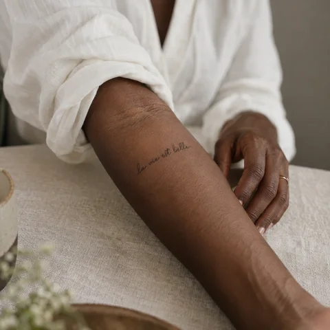 Simulation IA : tatouage quelques mots manuscrits sur l’avant-bras
